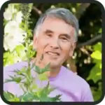 Illustrative portrait photo of a smiling man with grey hair in a pink shirt, a placeholder and not a customer